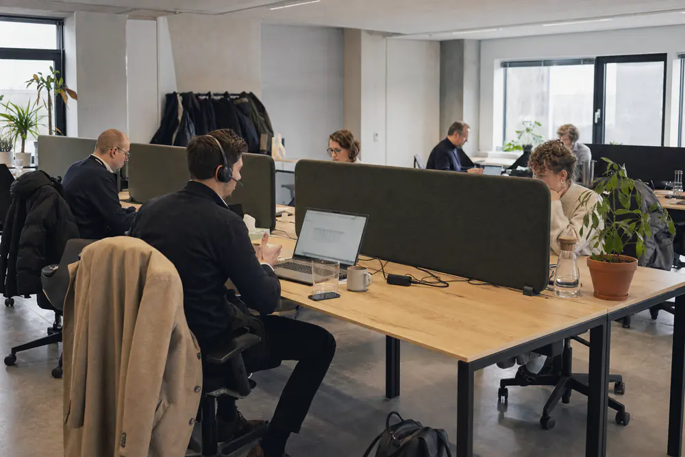 Akoestische bureauschermen van grijs vilt tussen tegenover elkaar staande bureaus