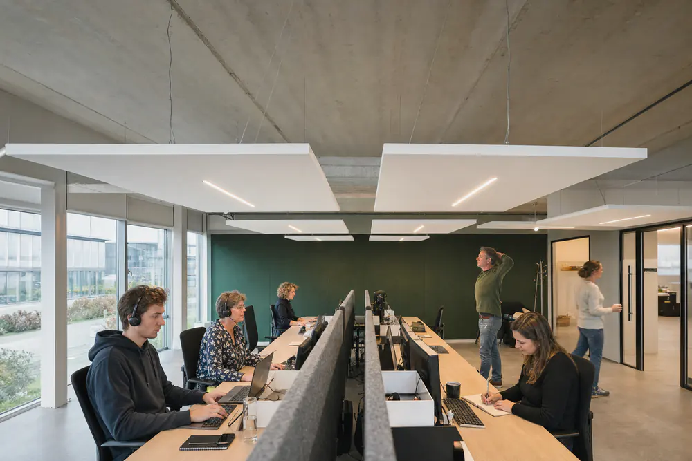 Klantenservice met headsets, bureauschermen, plafondeilanden en een groene viltwand