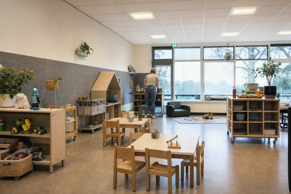 Groepsruimte van een kinderdagverblijf met een akoestisch plafond en zachte wandpanelen