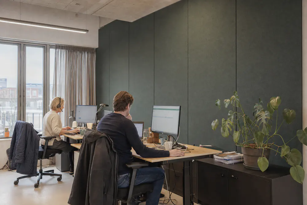 Werkplekken voor een wand met groene akoestische wandpanelen van vilt